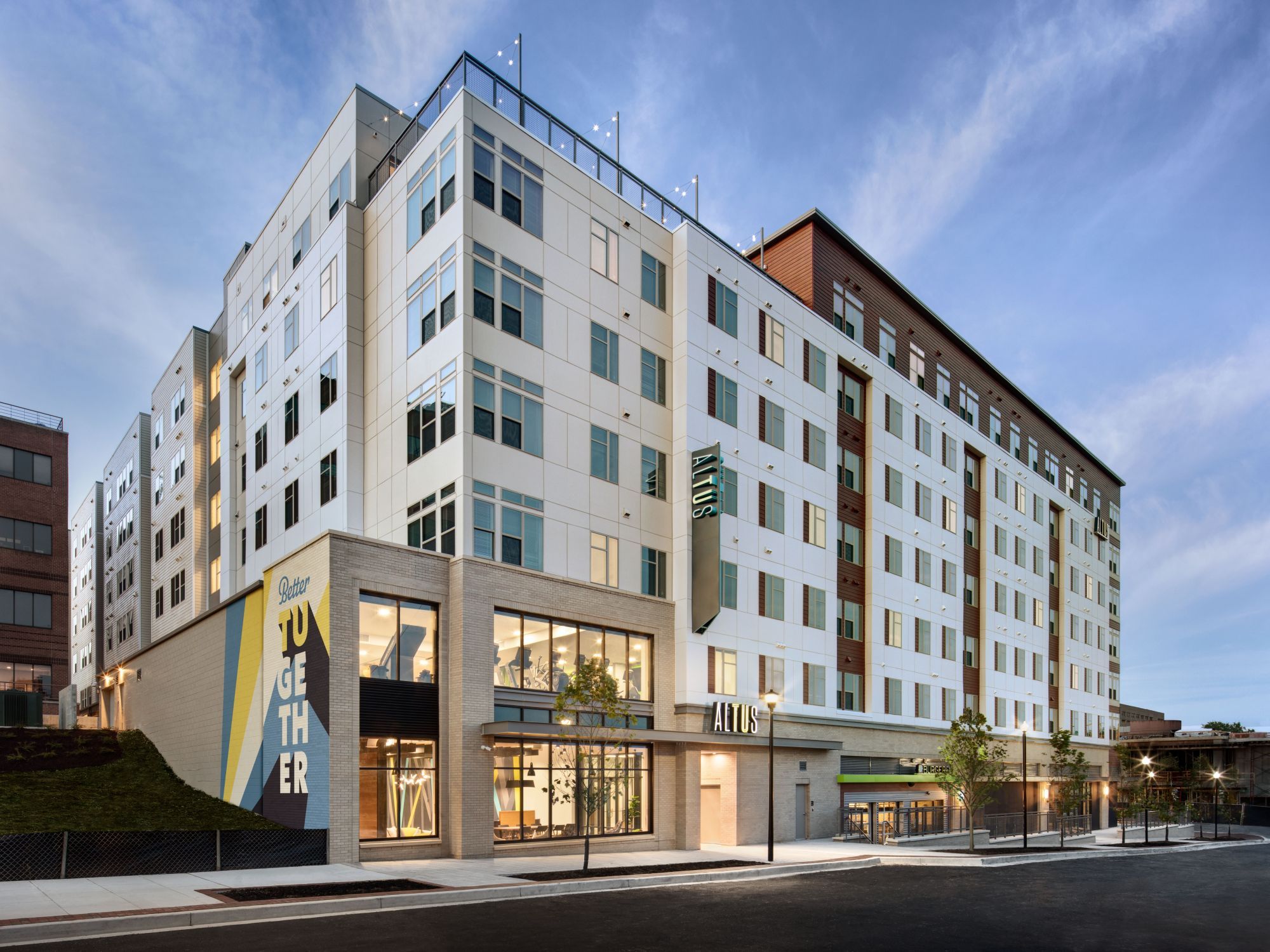 Modern multi-story building with large windows and a clean design against a blue sky.