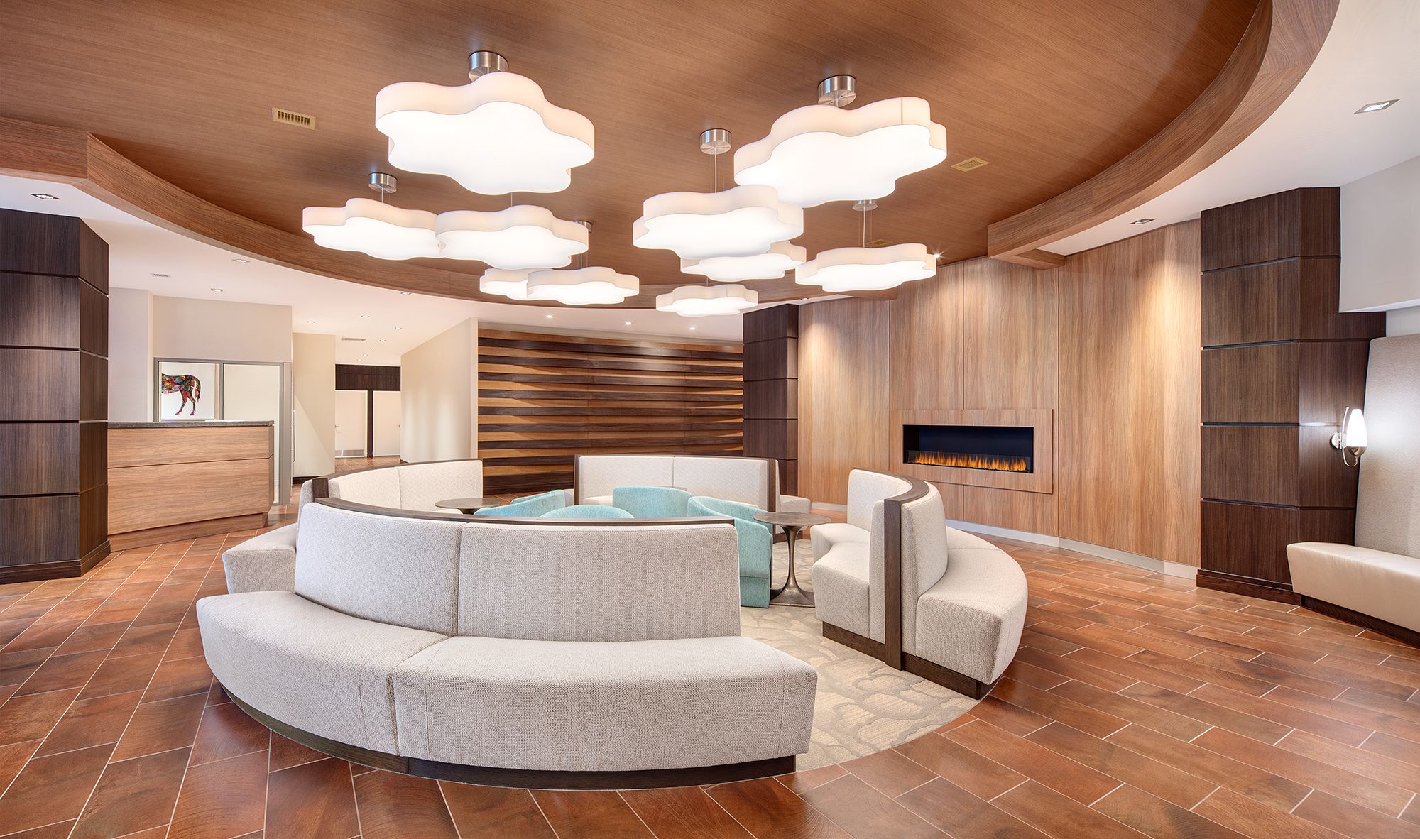 Modern lounge with curved seating and decorative light fixtures.