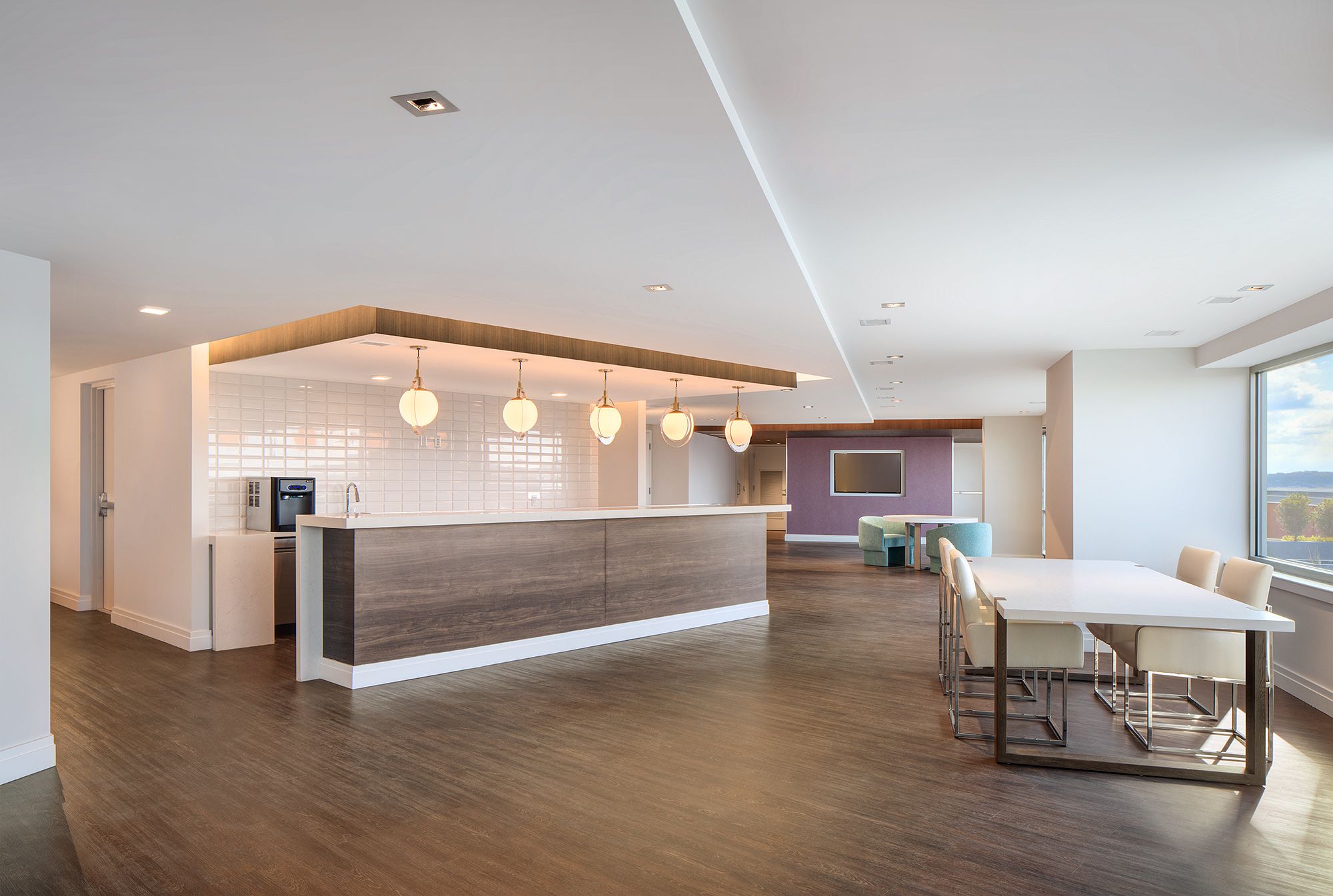 Modern interior with a reception area, seating, and large windows.