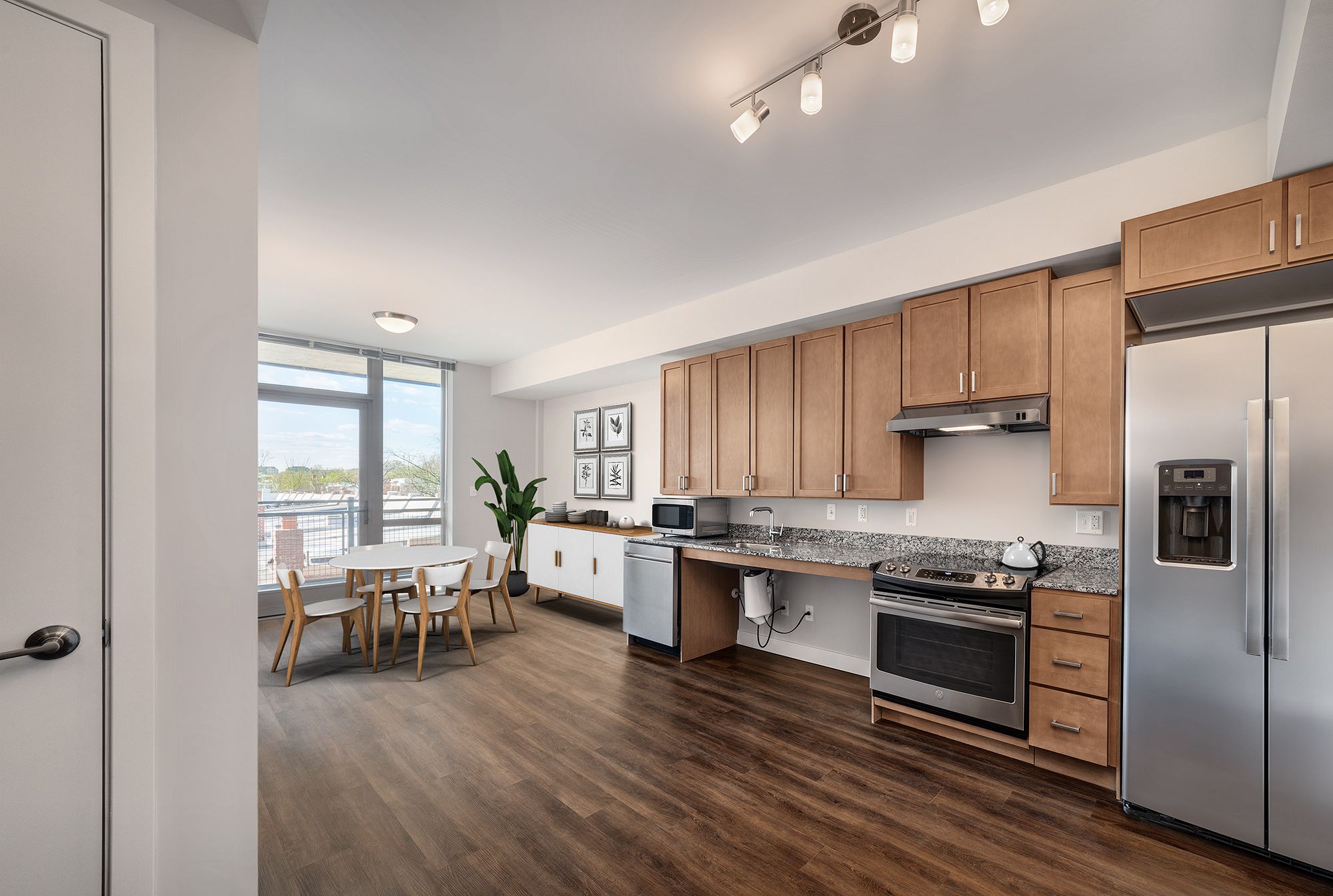 Modern kitchen with wooden cabinets, stainless steel appliances, and a dining area.