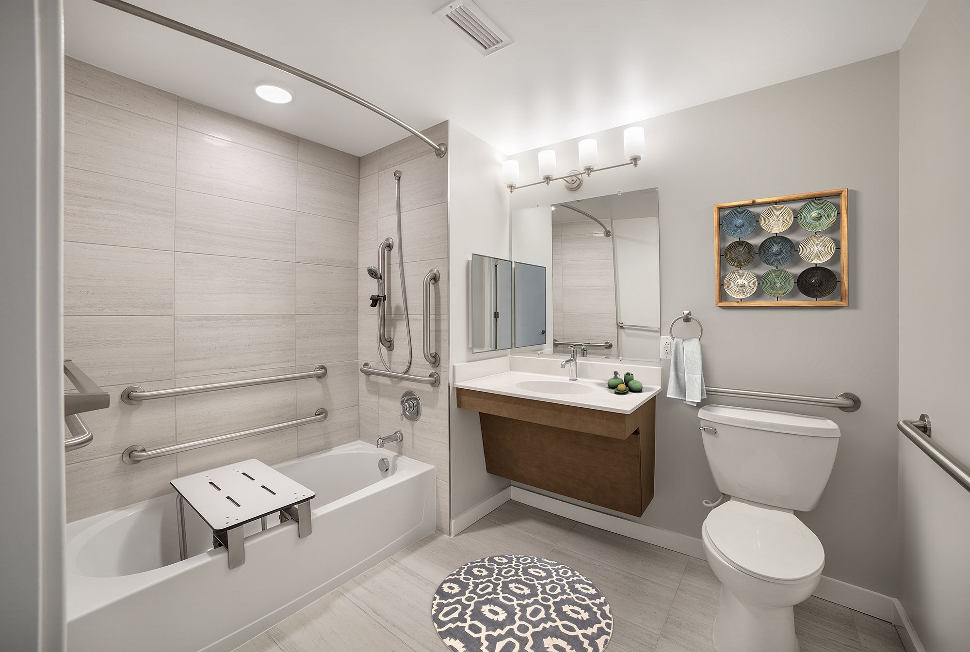 Modern bathroom with a bathtub, sink, toilet, and neutral decor.