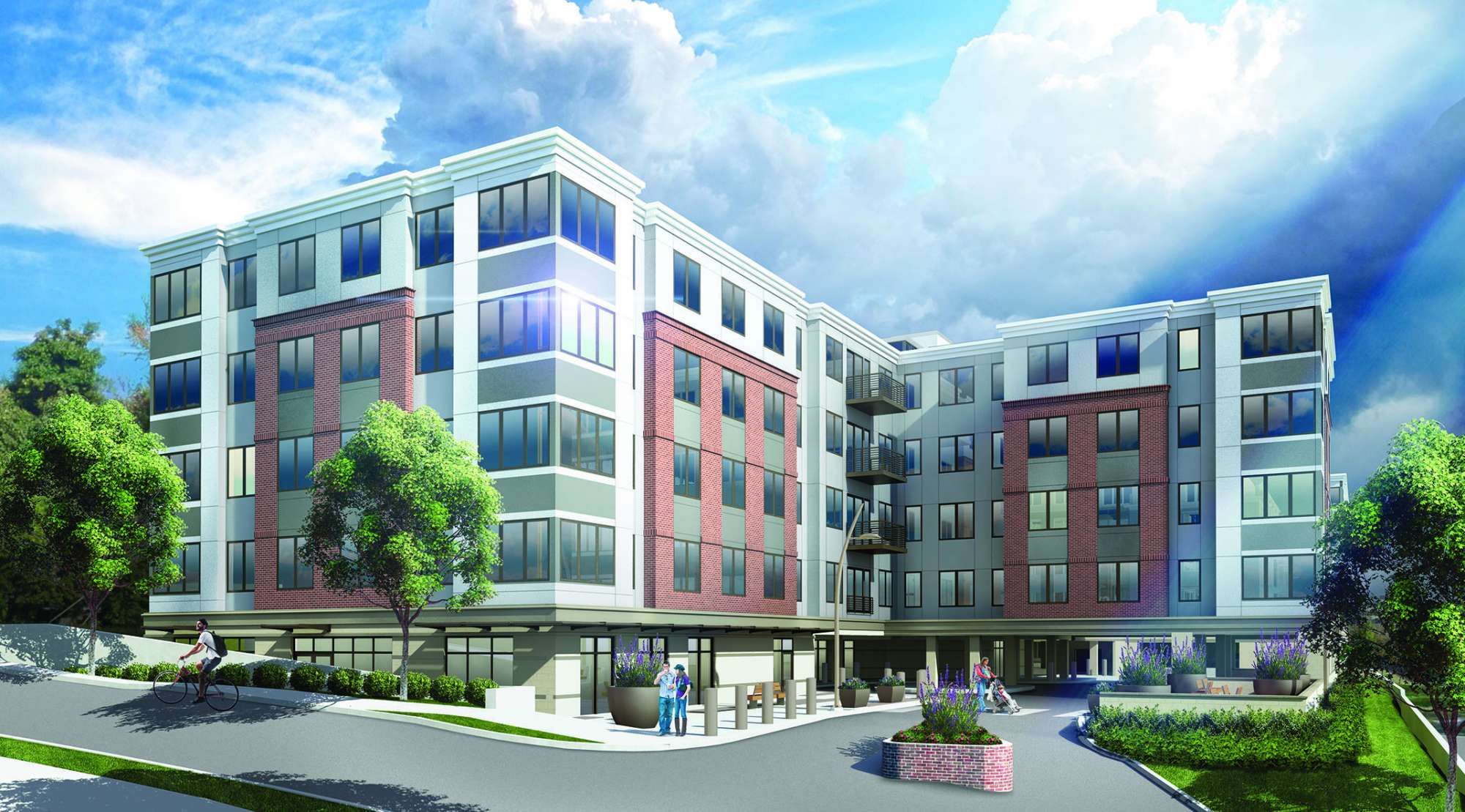 Modern multi-story building with a mix of red and gray exterior, surrounded by greenery.
