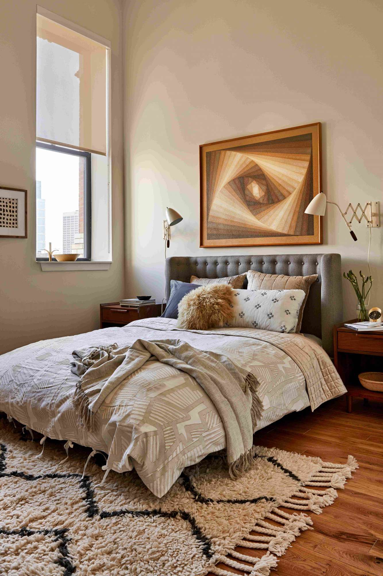 Cozy bedroom with a large bed, artwork, and warm wooden accents.