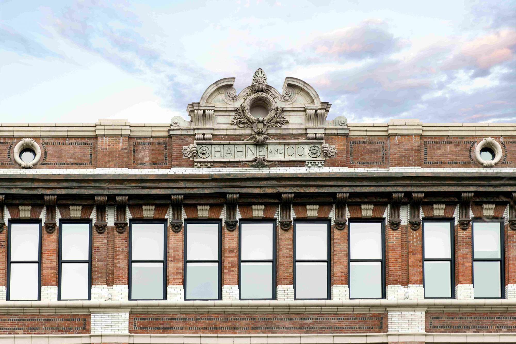 Detailed brick facade of a historic building with decorative elements and windows.