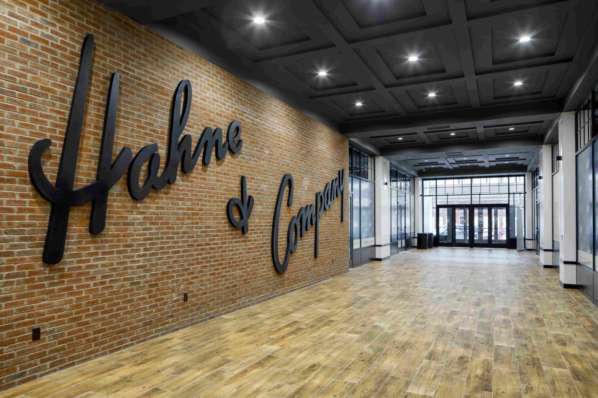 Interior space featuring a brick wall with a large black sign reading "Hakme & Company."