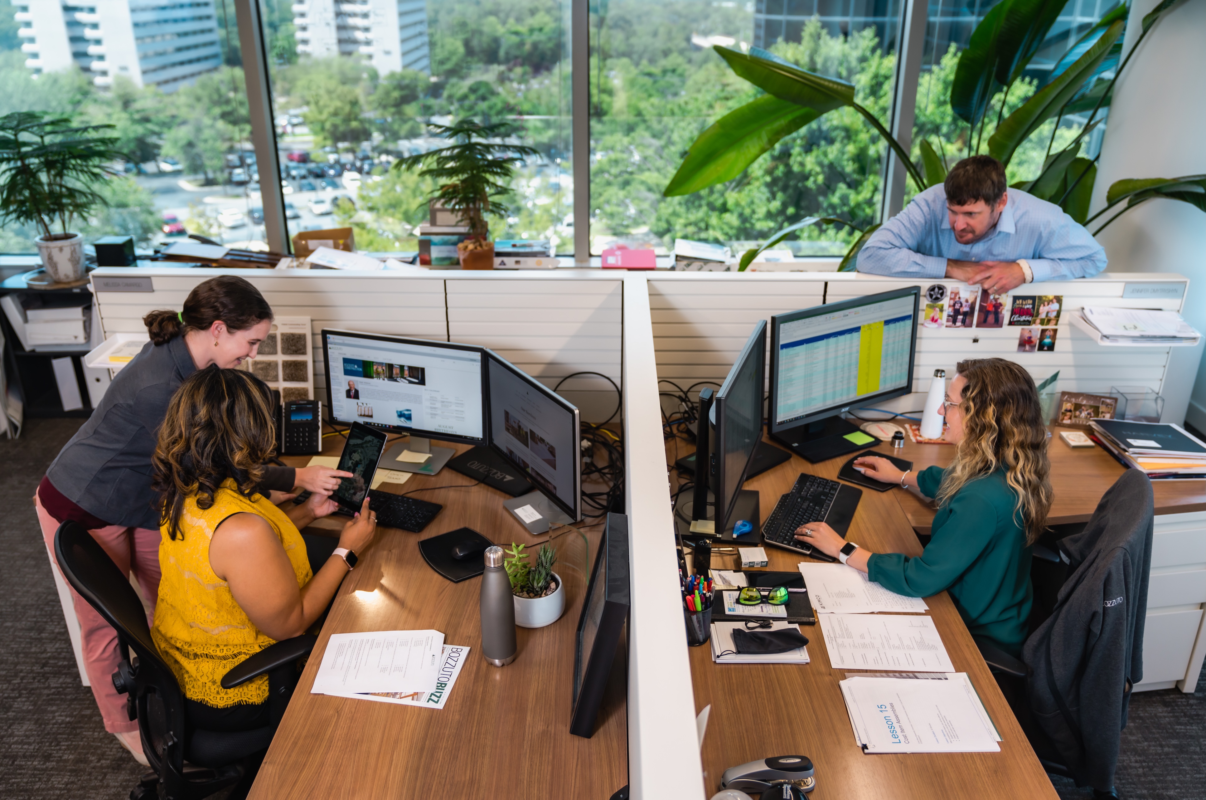 Two people working at desks with computers in an office environment.