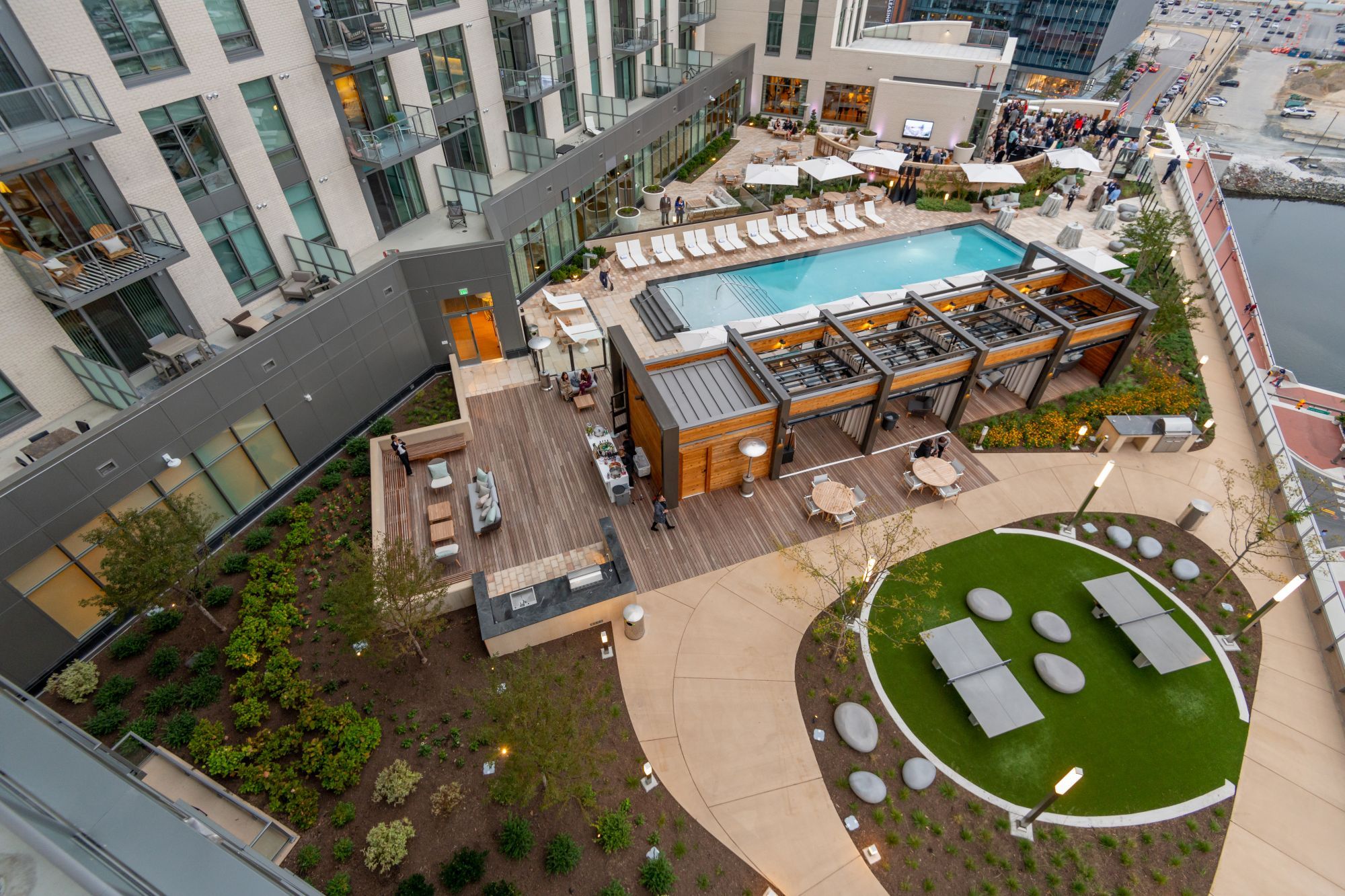 Aerial view of a modern outdoor pool area surrounded by landscaped gardens and seating.