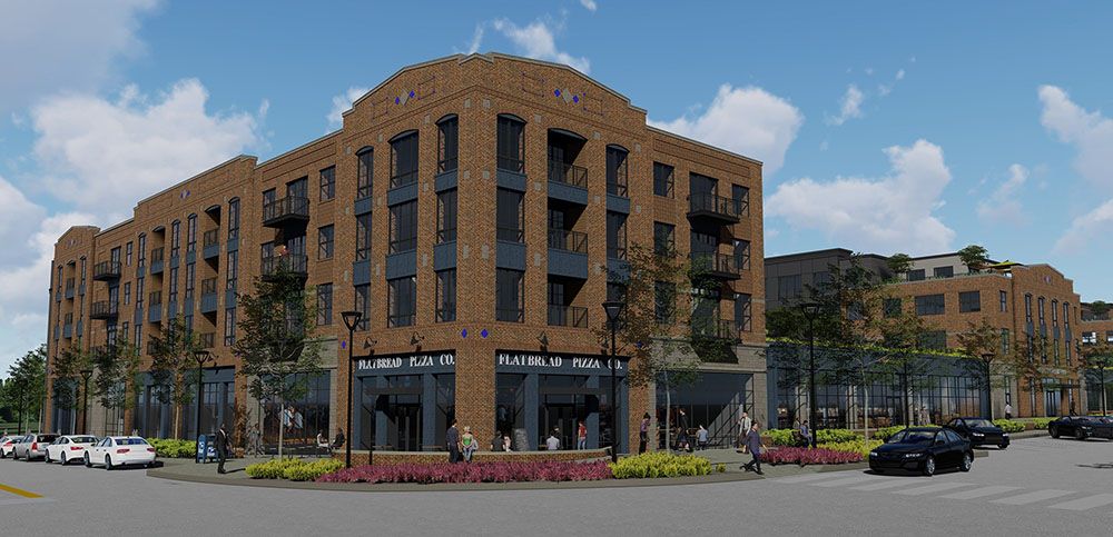 Modern brick building with multiple floors, storefronts, and landscaped surroundings.