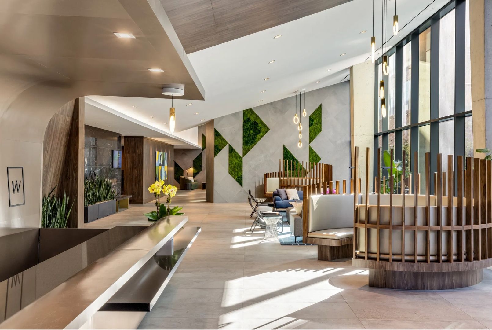 Modern lobby with natural elements, large windows, and sleek wooden accents.