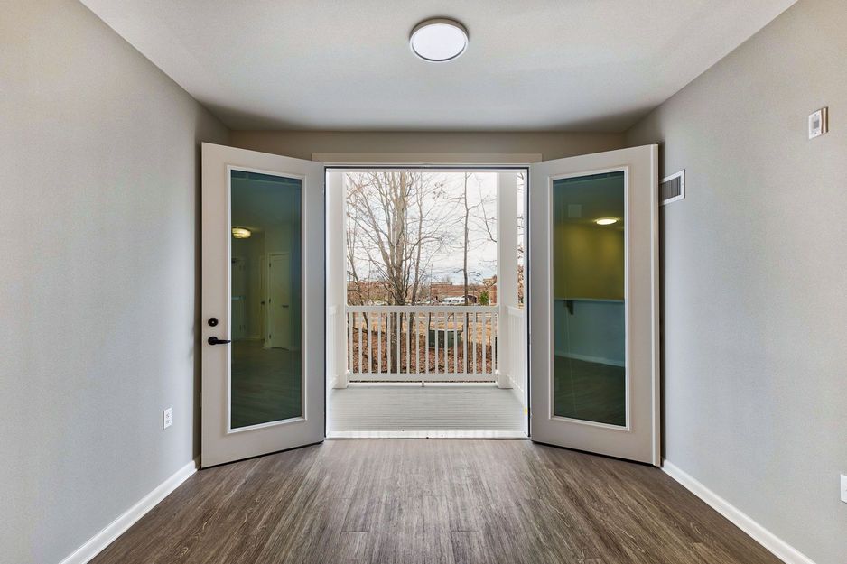 Open double doors leading to a view of trees outside.