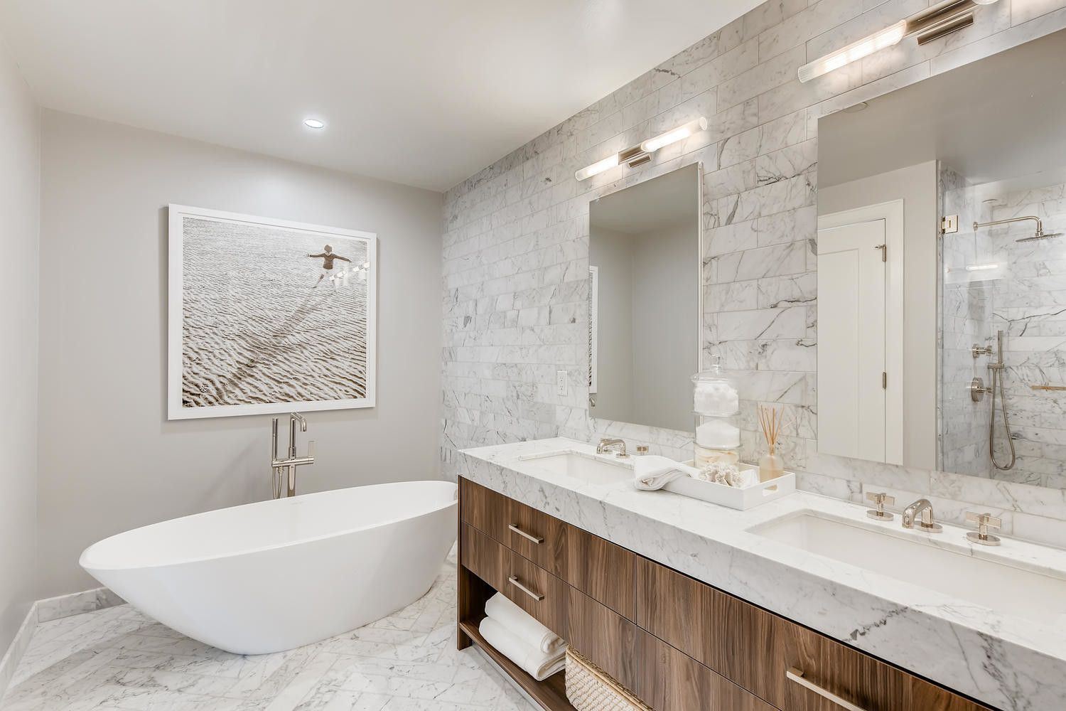 Modern bathroom featuring a freestanding tub, dual sinks, and stylish decor.