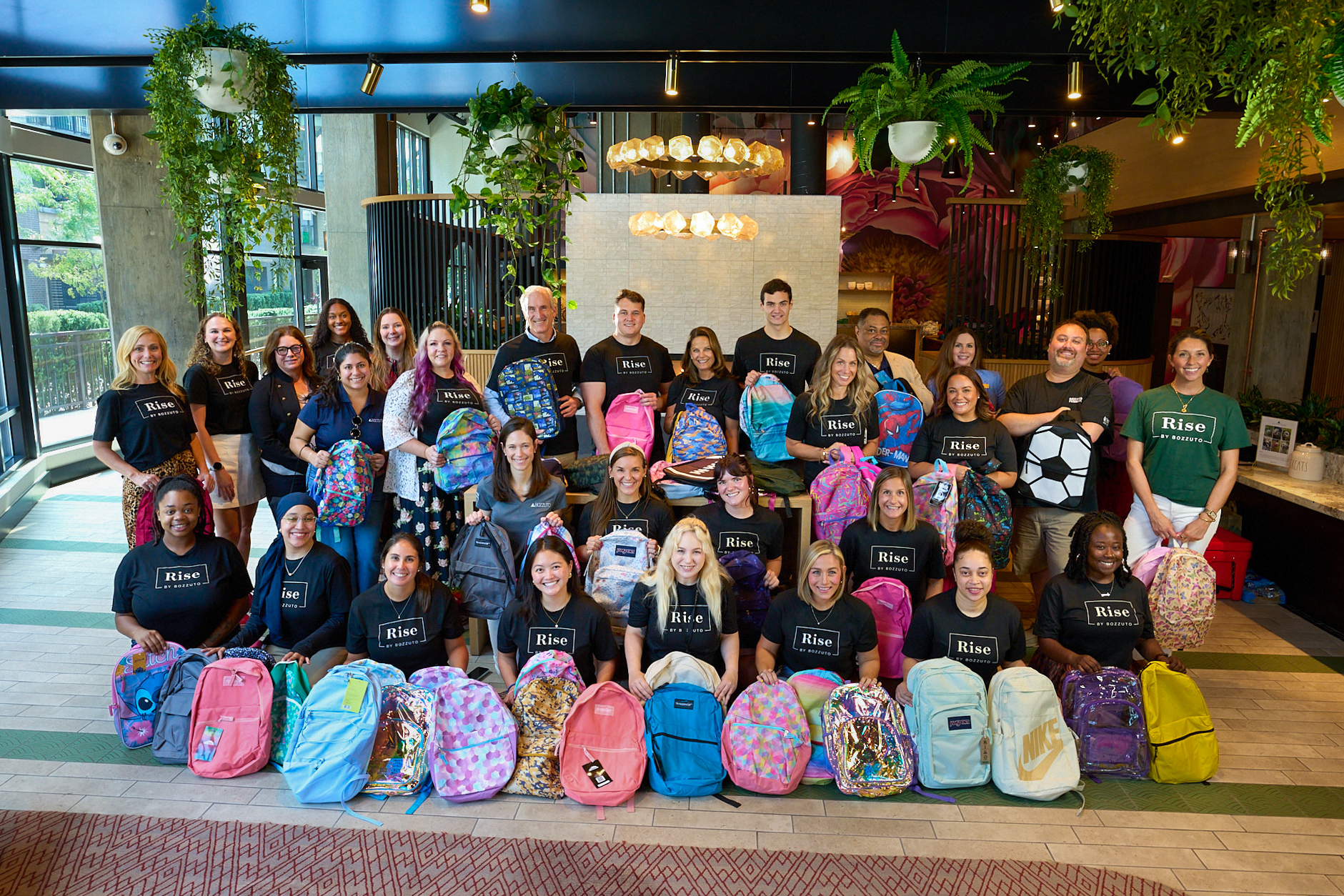 Group of people with colorful backpacks in a community setting.