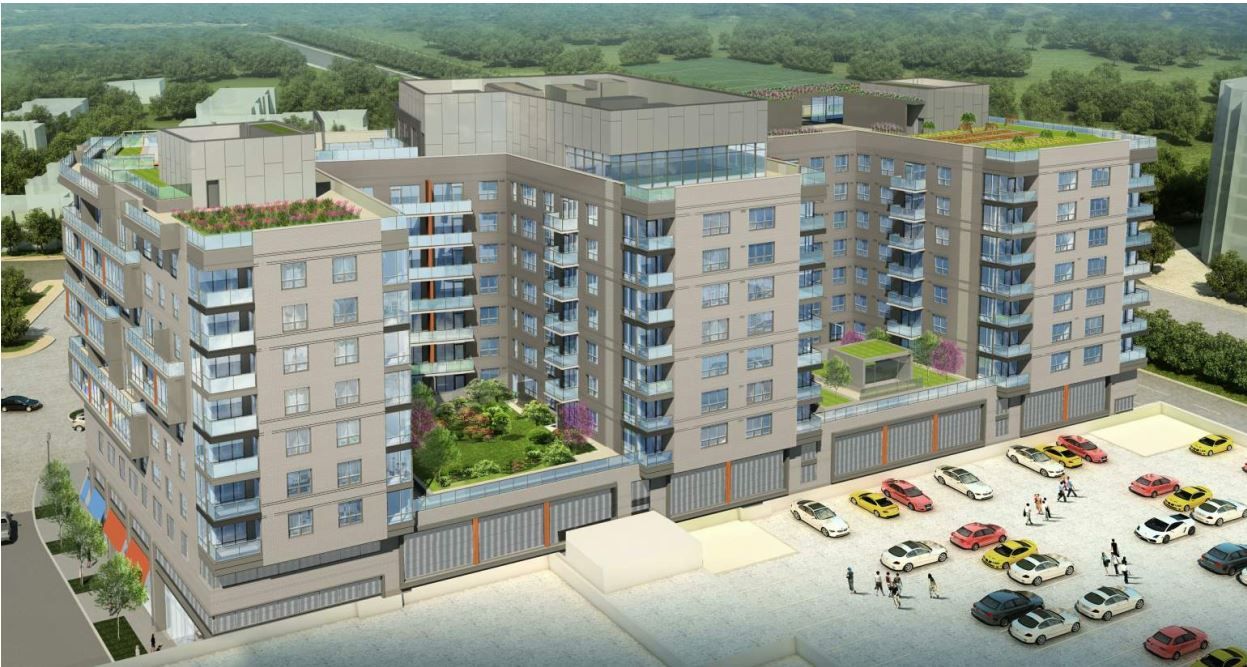 Modern multi-story apartment building with green terraces and surrounding parking area.