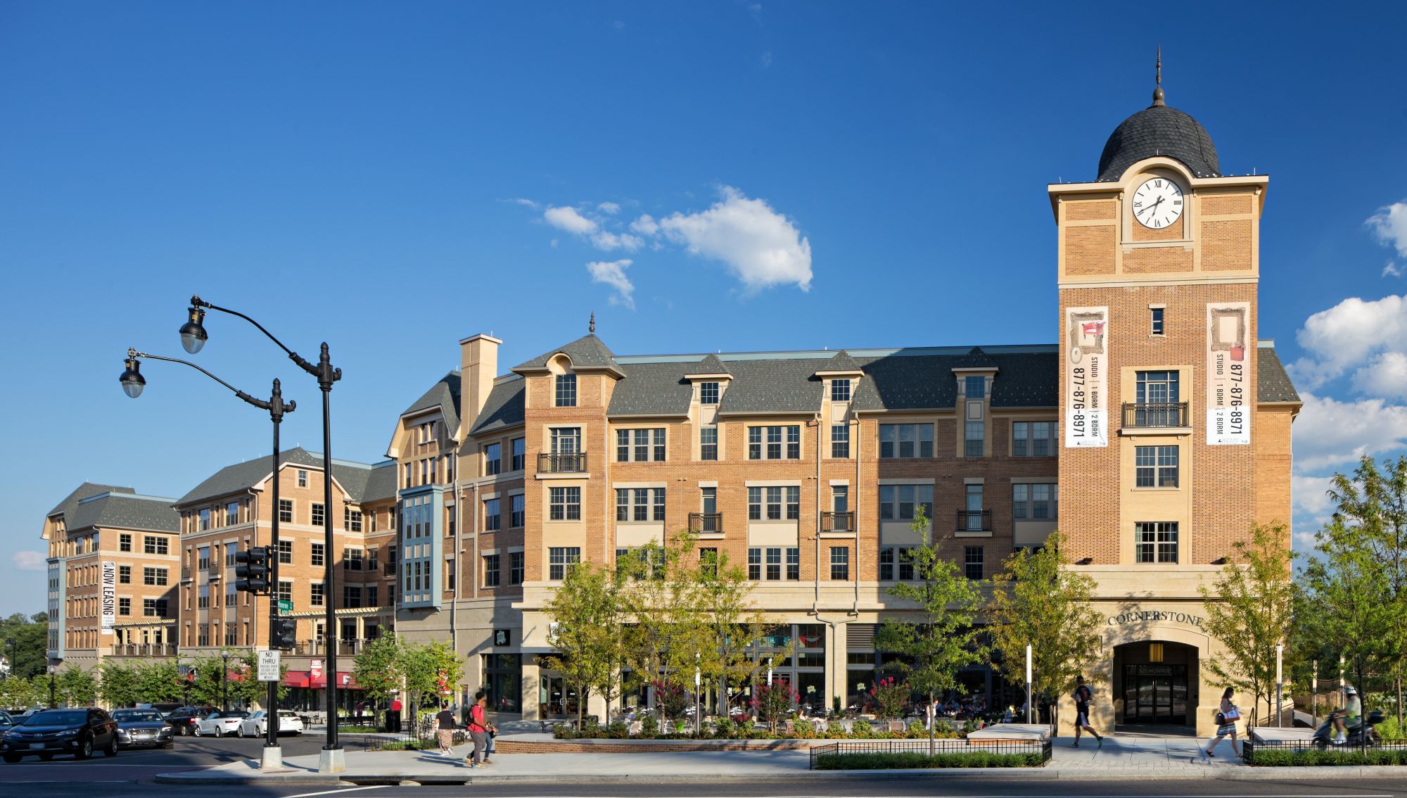 A brick building with a clock tower and modern architecture under a blue sky.