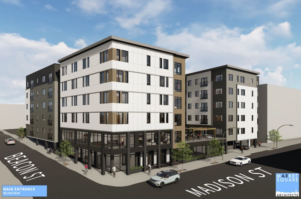 Modern multi-story building at a street corner with landscaped surroundings.