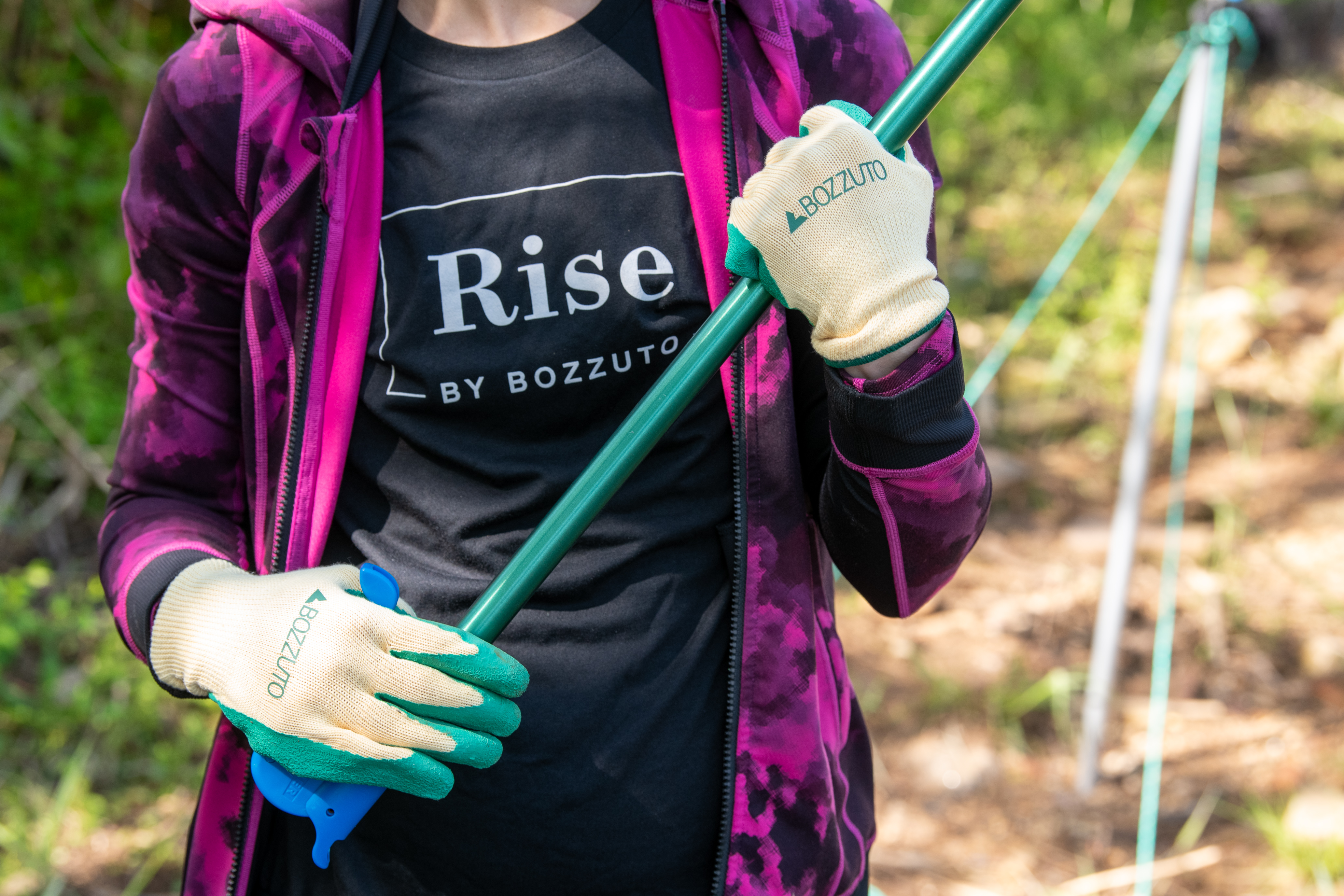 Person holding a gardening tool in a natural setting.