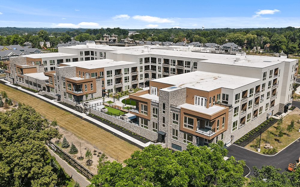 Modern multi-story apartment complex with landscaped grounds.