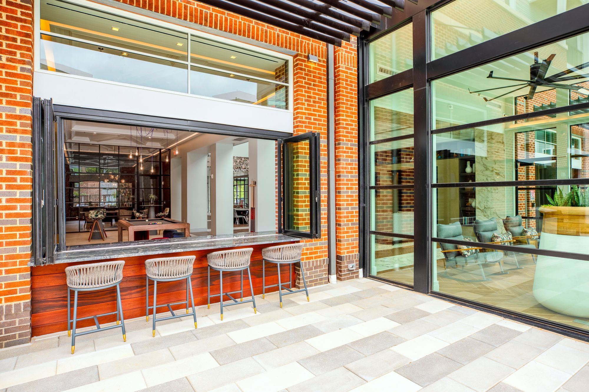 A modern café with large windows and outdoor seating.
