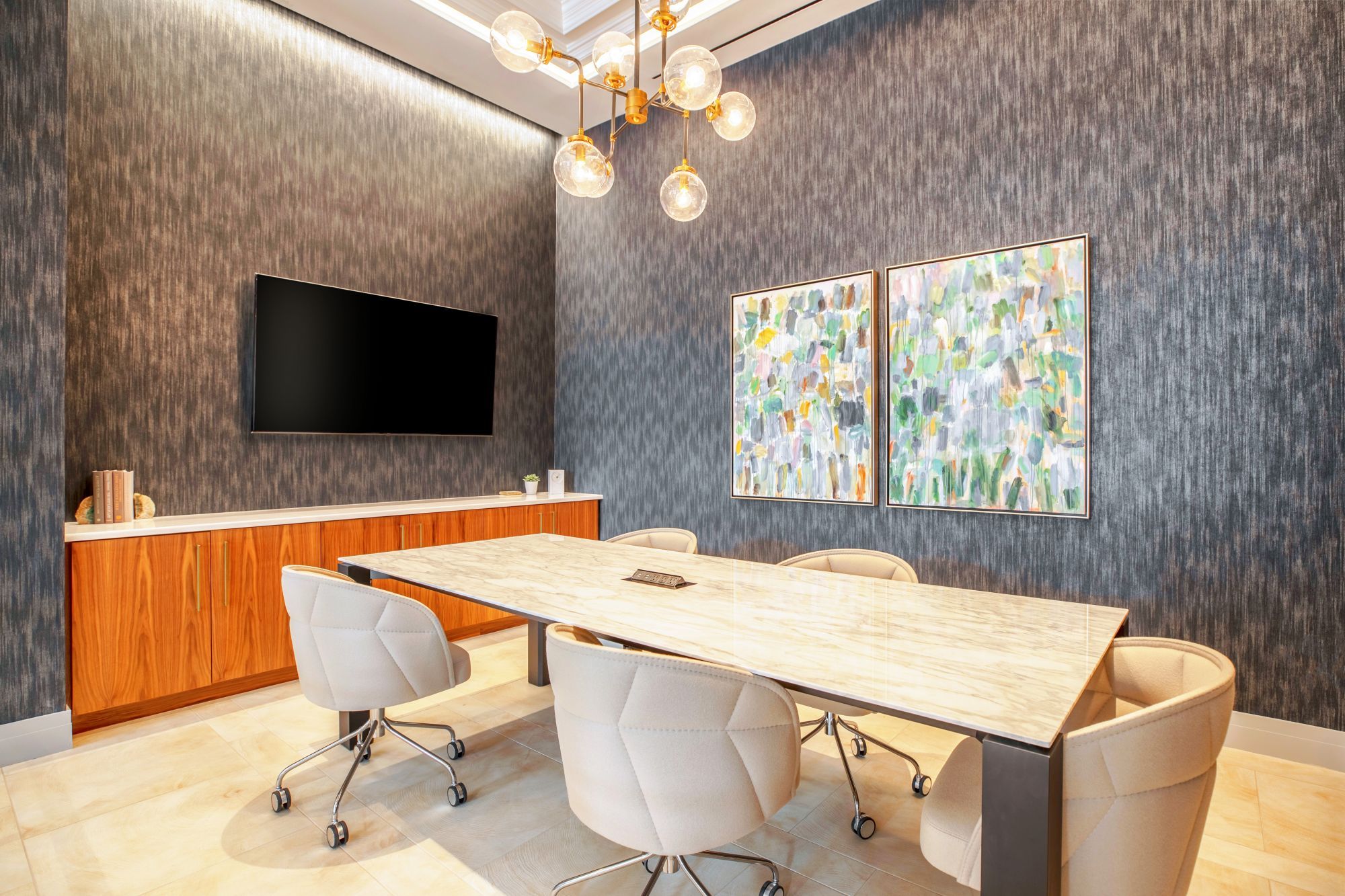 Modern conference room with a large table, stylish chairs, and abstract artwork.