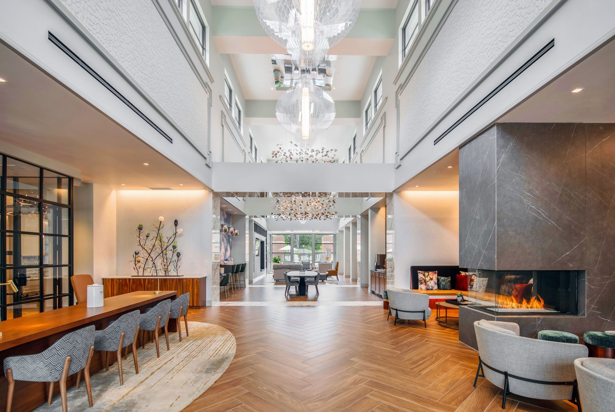 Spacious modern interior with a high ceiling, elegant lighting, and stylish furnishings.