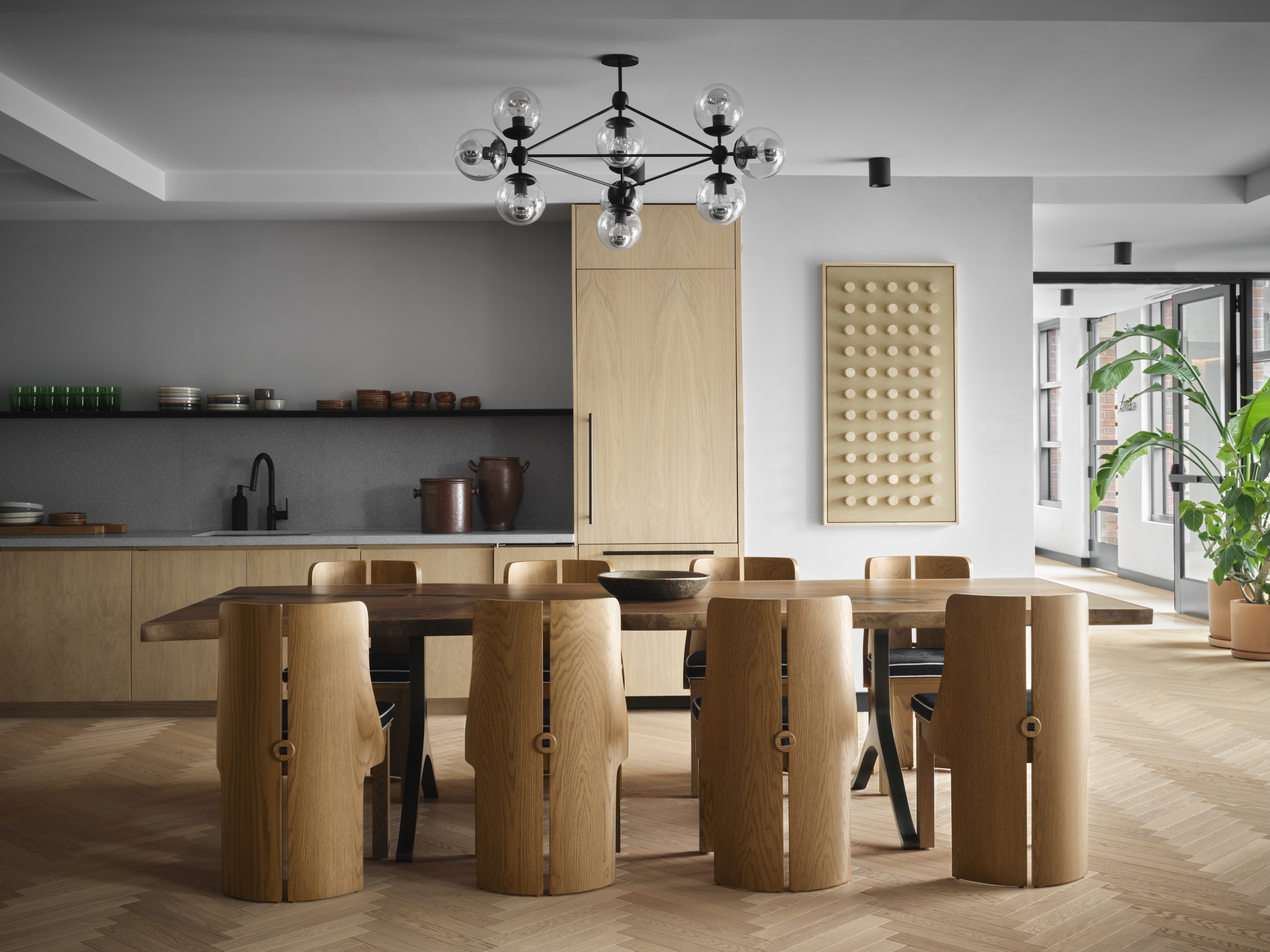 Modern dining room with wooden table and unique cylindrical chairs.