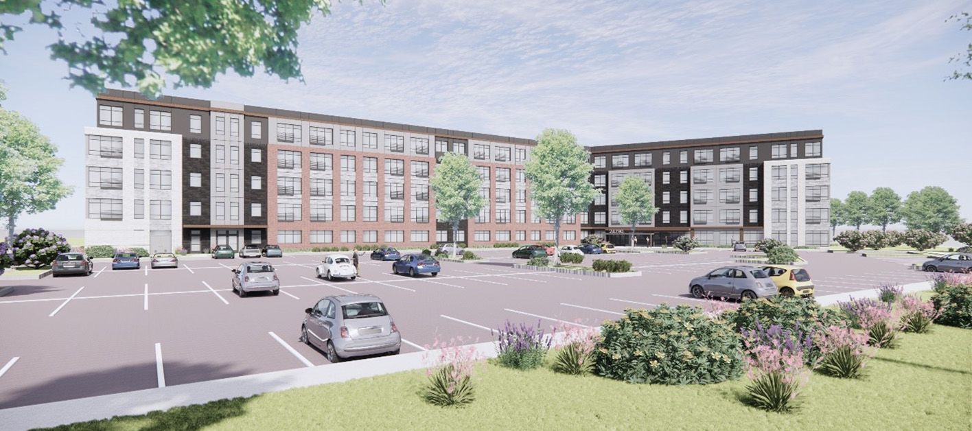 Modern multi-story building with parking lot and landscaped areas.
