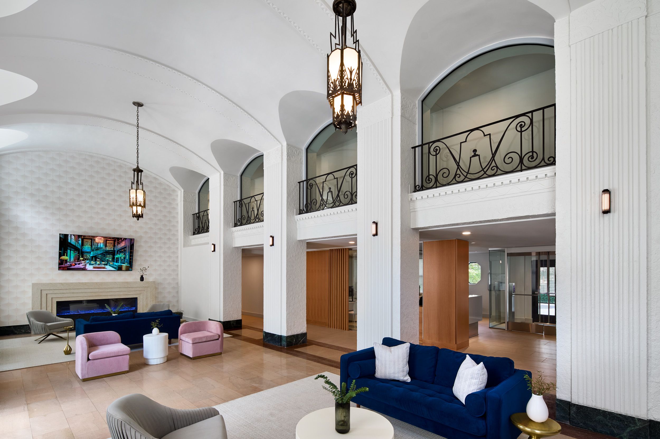 Modern airy lobby with high ceilings, elegant seating, and stylish lighting fixtures.