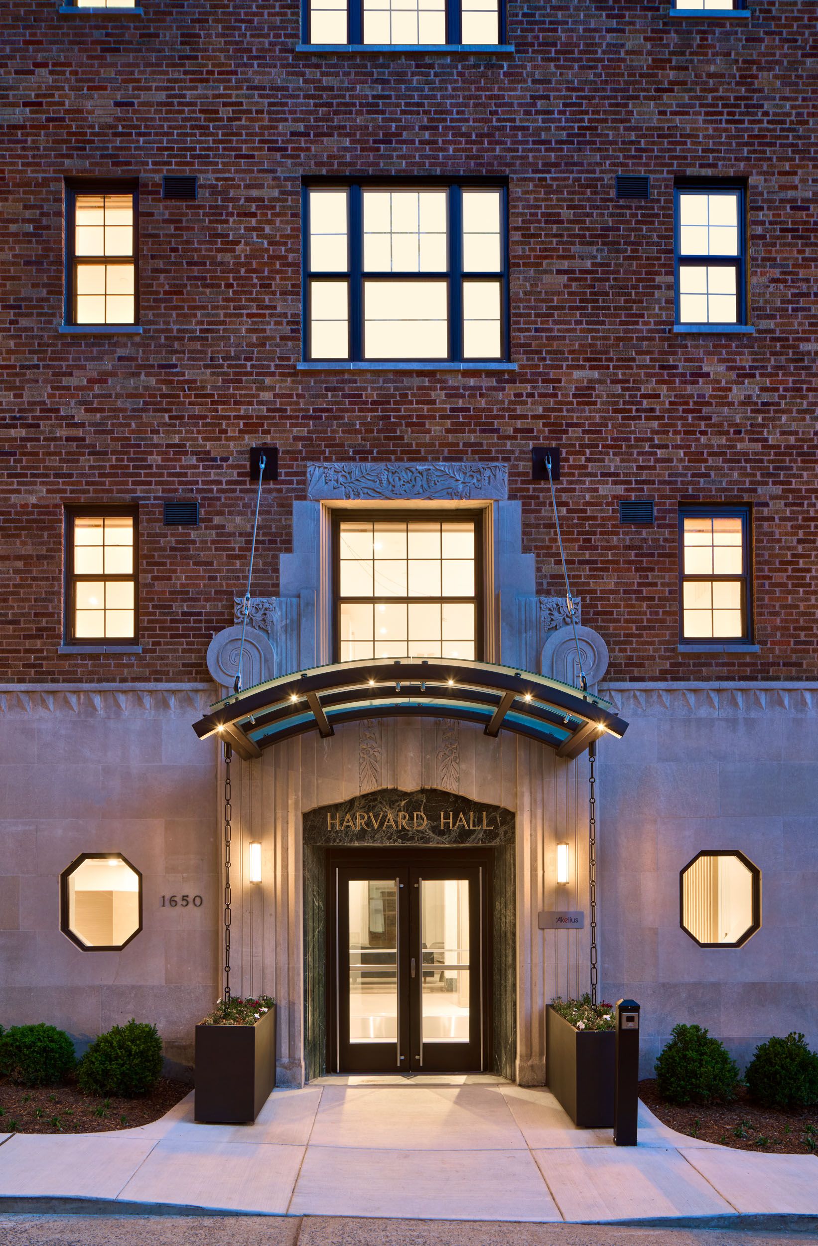 Classic brick building entrance with decorative arch and large windows.