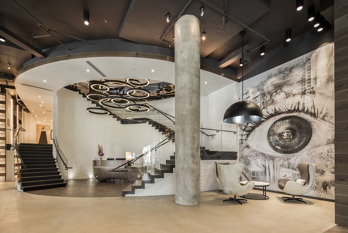 Modern interior with a spiral staircase, large eye mural, and contemporary furniture.