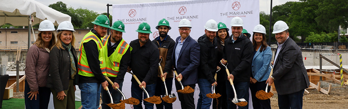 Group of people in hard hats at a groundbreaking ceremony.