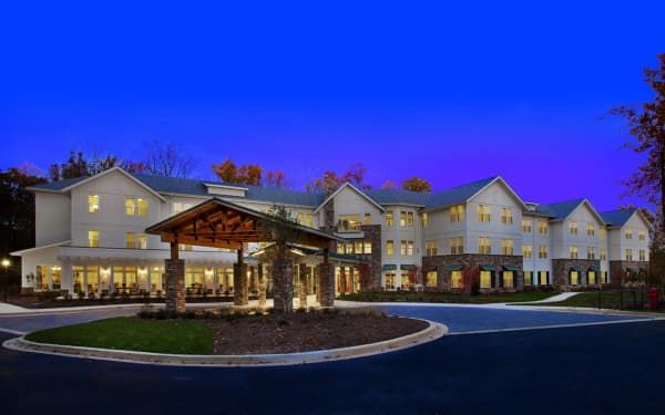 Modern hotel building at dusk with a welcoming entrance and landscaped surroundings.