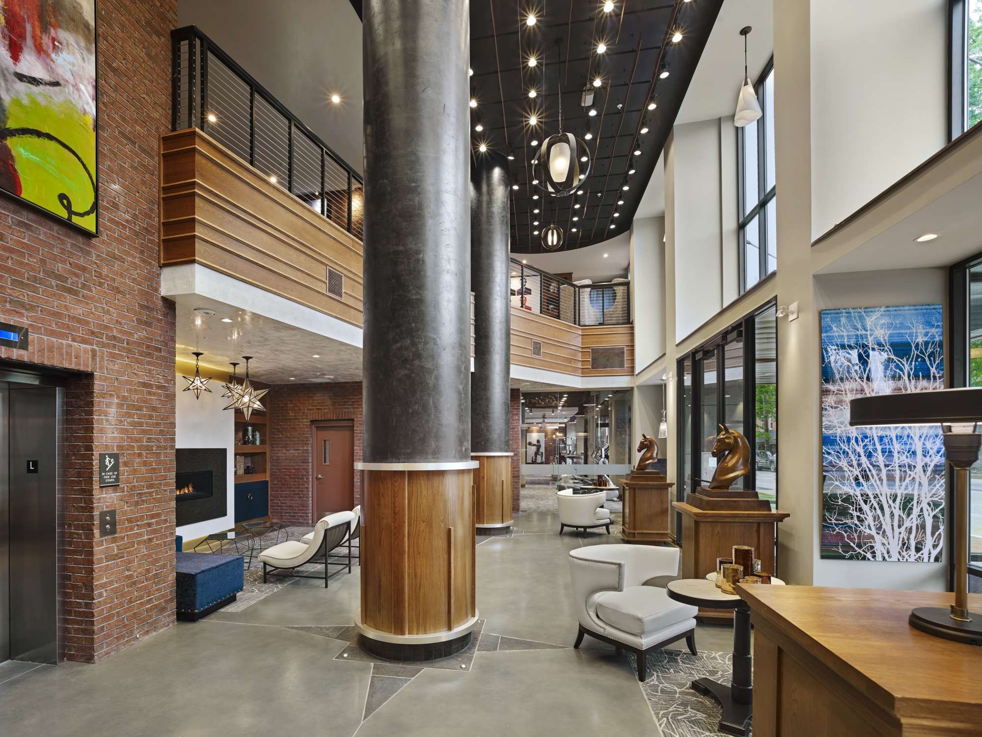 Modern lobby with tall pillars, large windows, and contemporary furnishings.