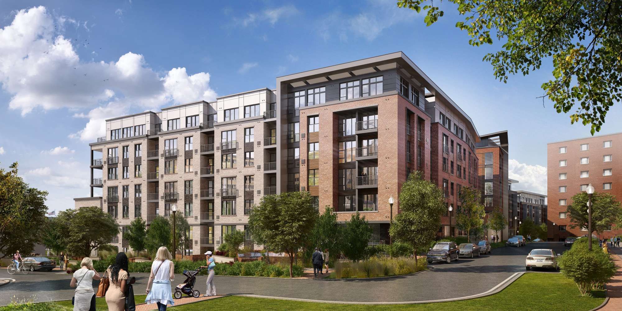 Modern multi-story apartment building surrounded by greenery and a clear blue sky.