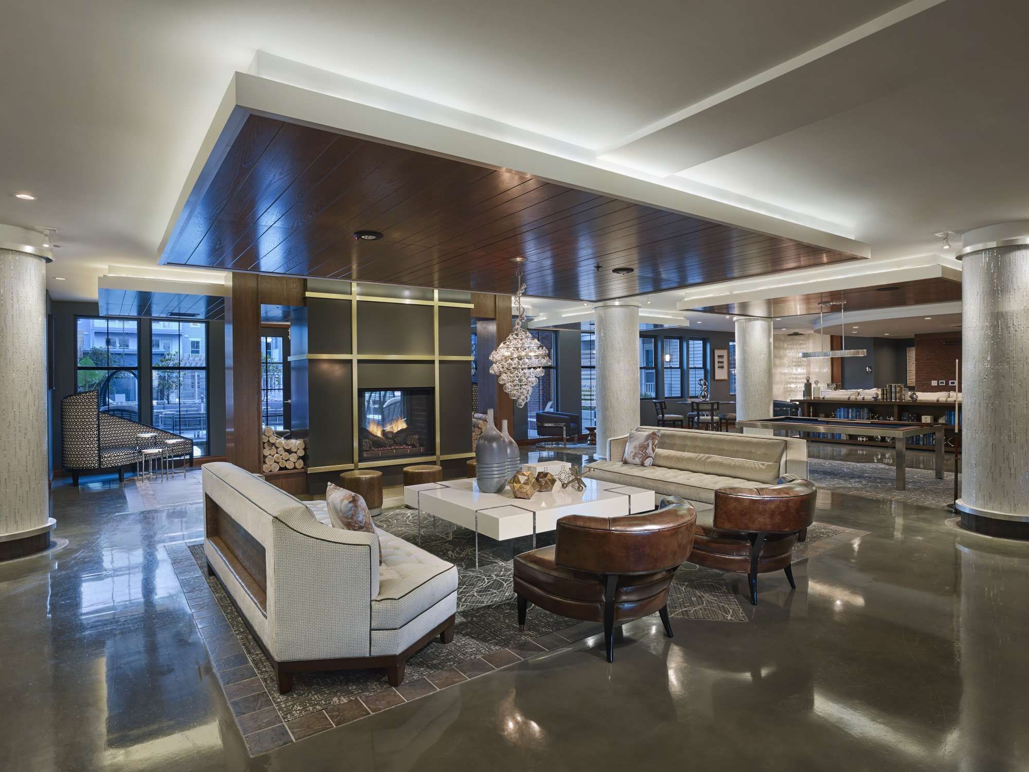 Modern lobby with sleek furniture, polished floors, and warm lighting.