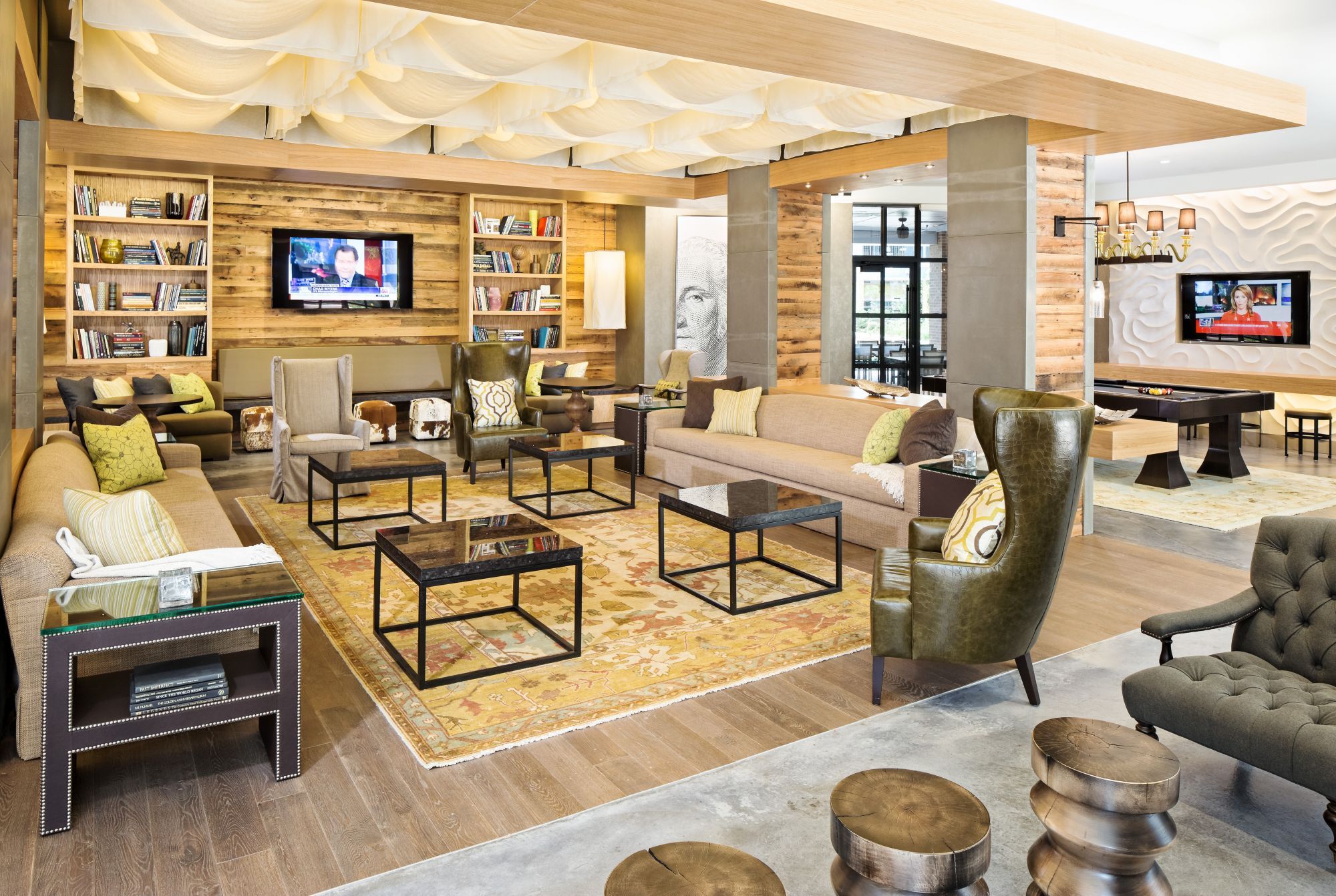 Modern lounge with comfortable seating, bookshelves, and a warm, inviting atmosphere.