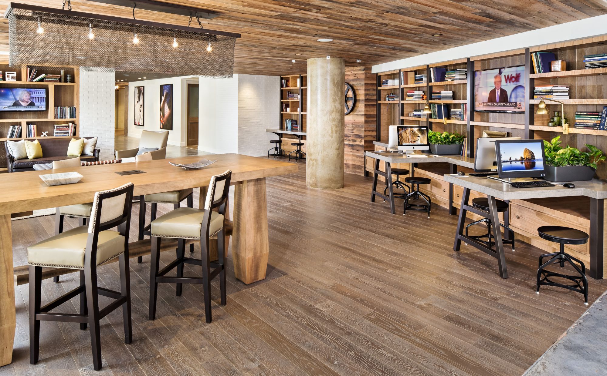 Modern office space with wooden furniture, bookshelves, and workstations.