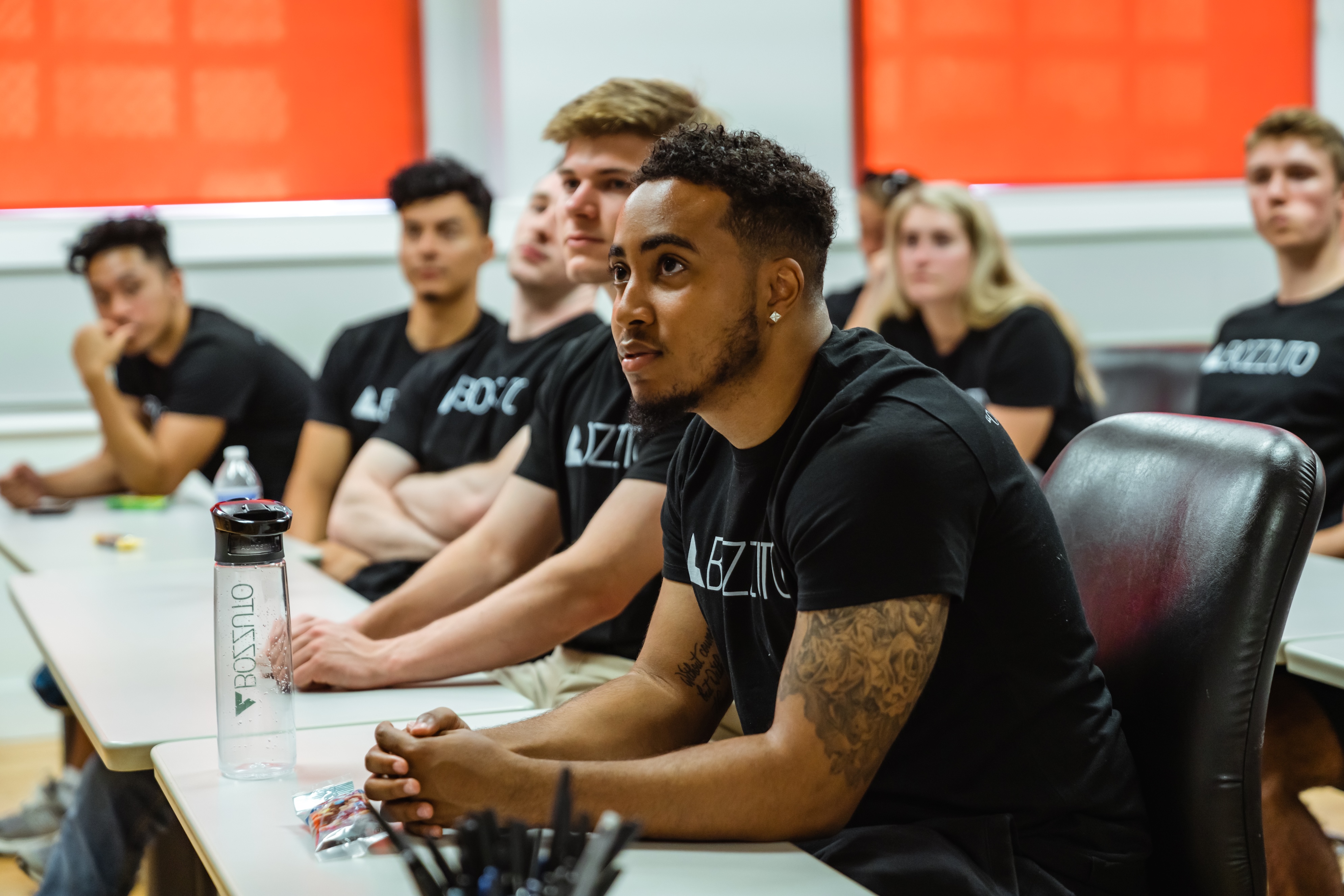 Diverse group of students attentively listening in a classroom.