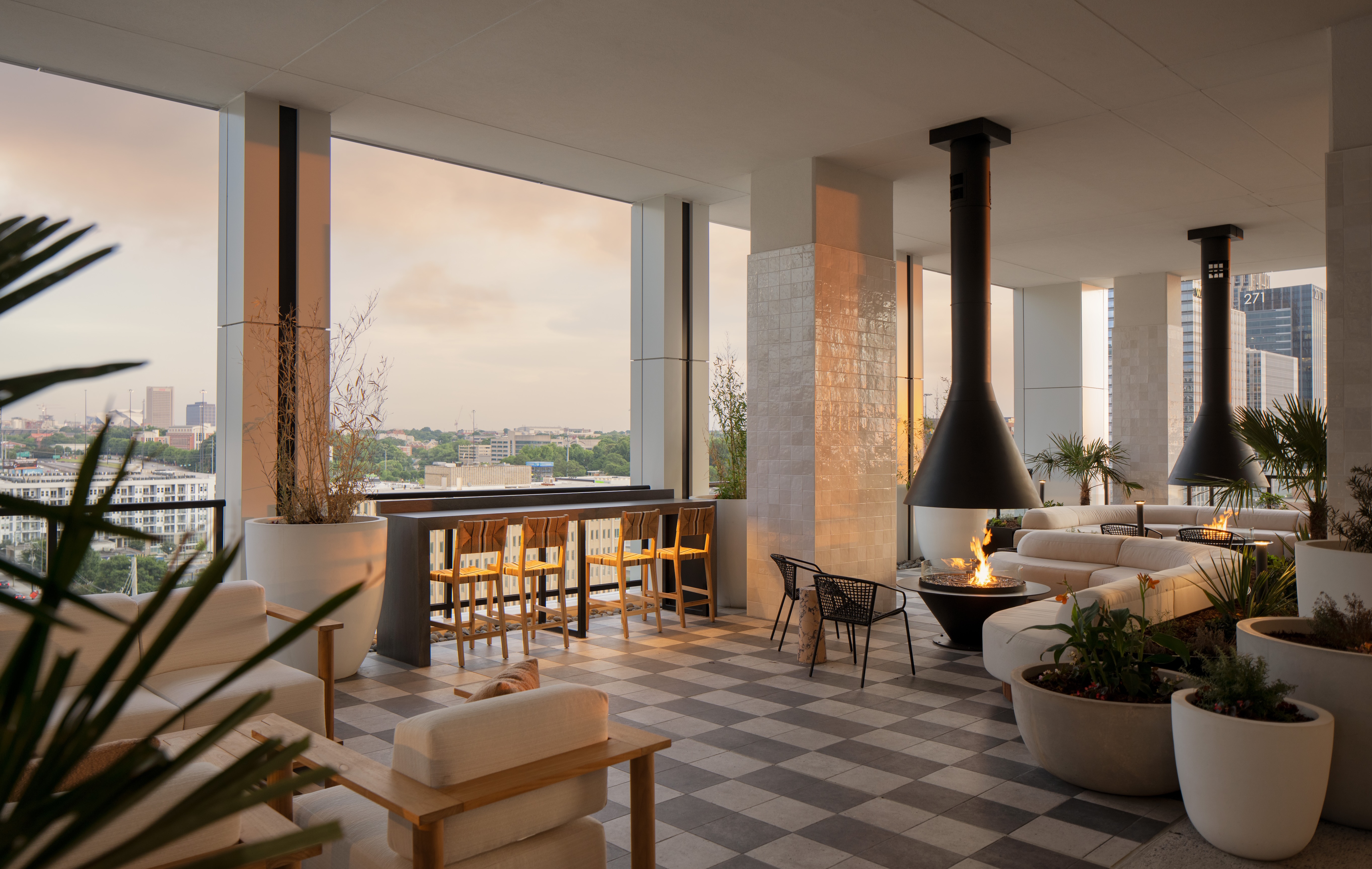 Modern terrace with plants, seating, and a view of the city skyline.