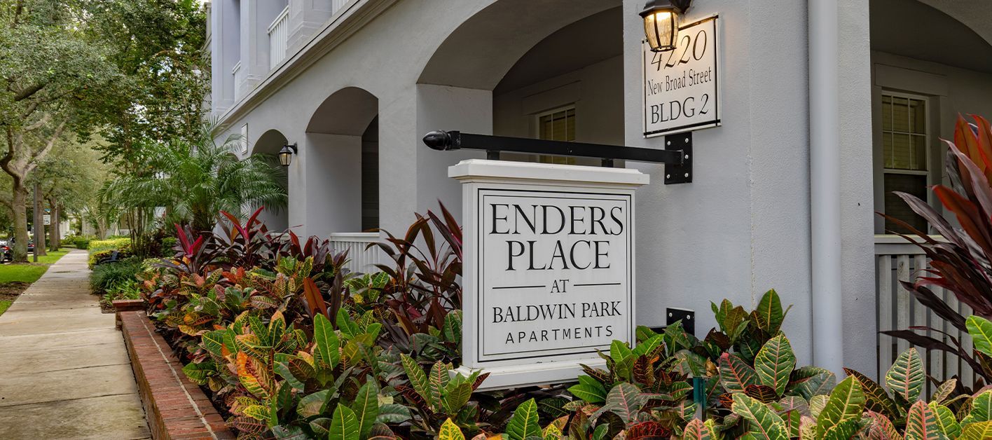 Sign for Enders Place apartments surrounded by lush greenery.