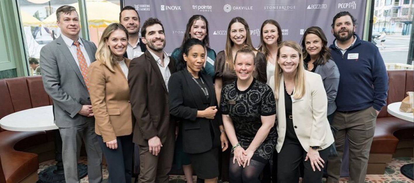 Group photo of diverse professionals smiling at a networking event.