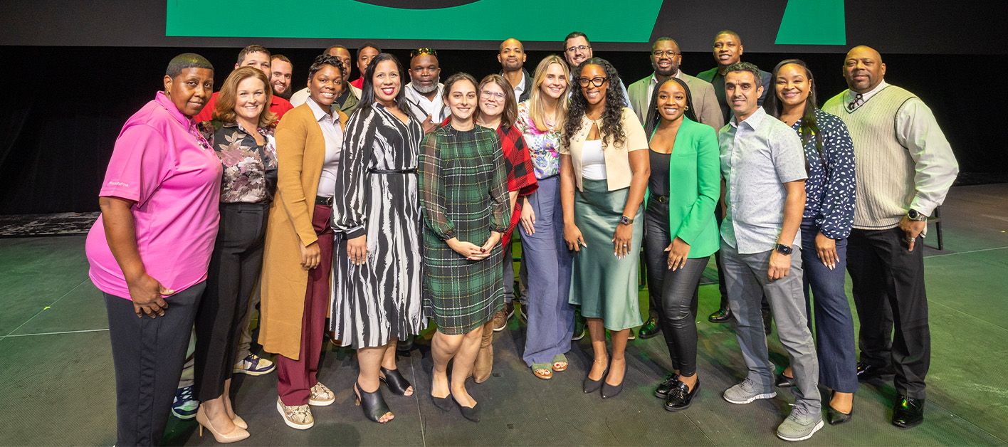 Group photo of diverse individuals on stage at an event.