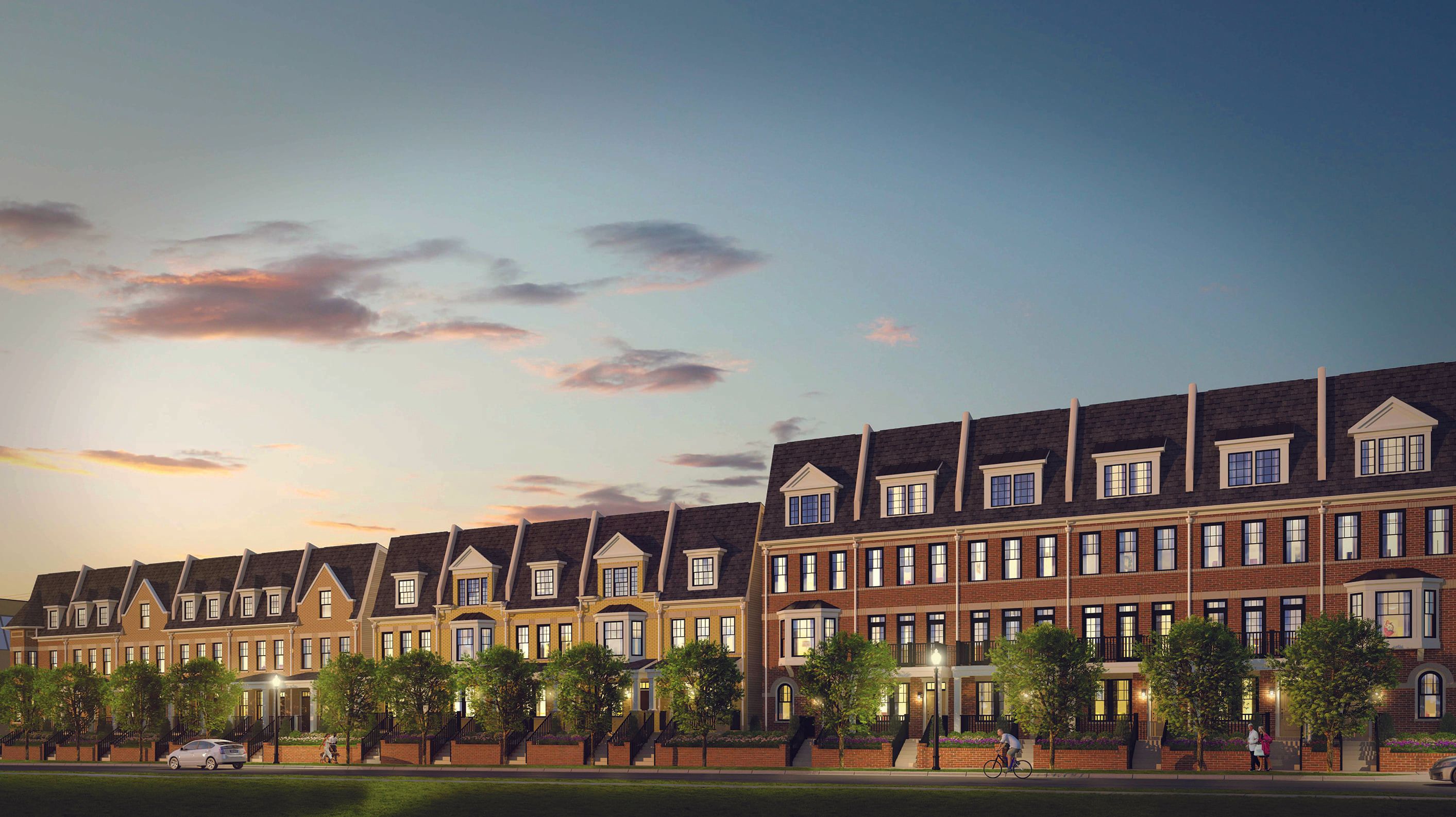 Row of townhouses at dusk with trees lining the walkway.