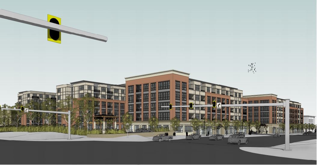 New modern apartment complex with traffic lights and surrounding landscaping.