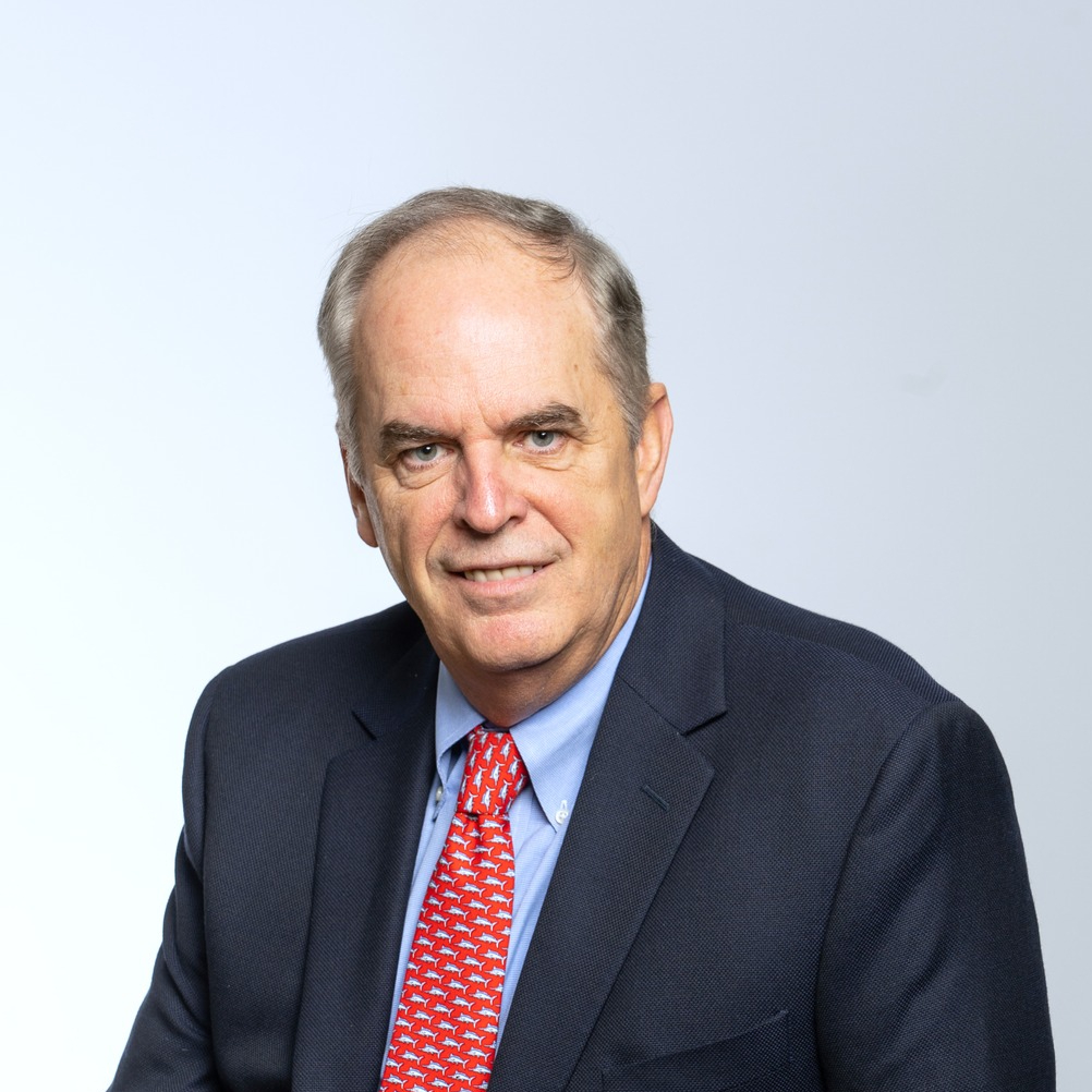 Portrait of John Martin wearing a suit and tie against a light background.