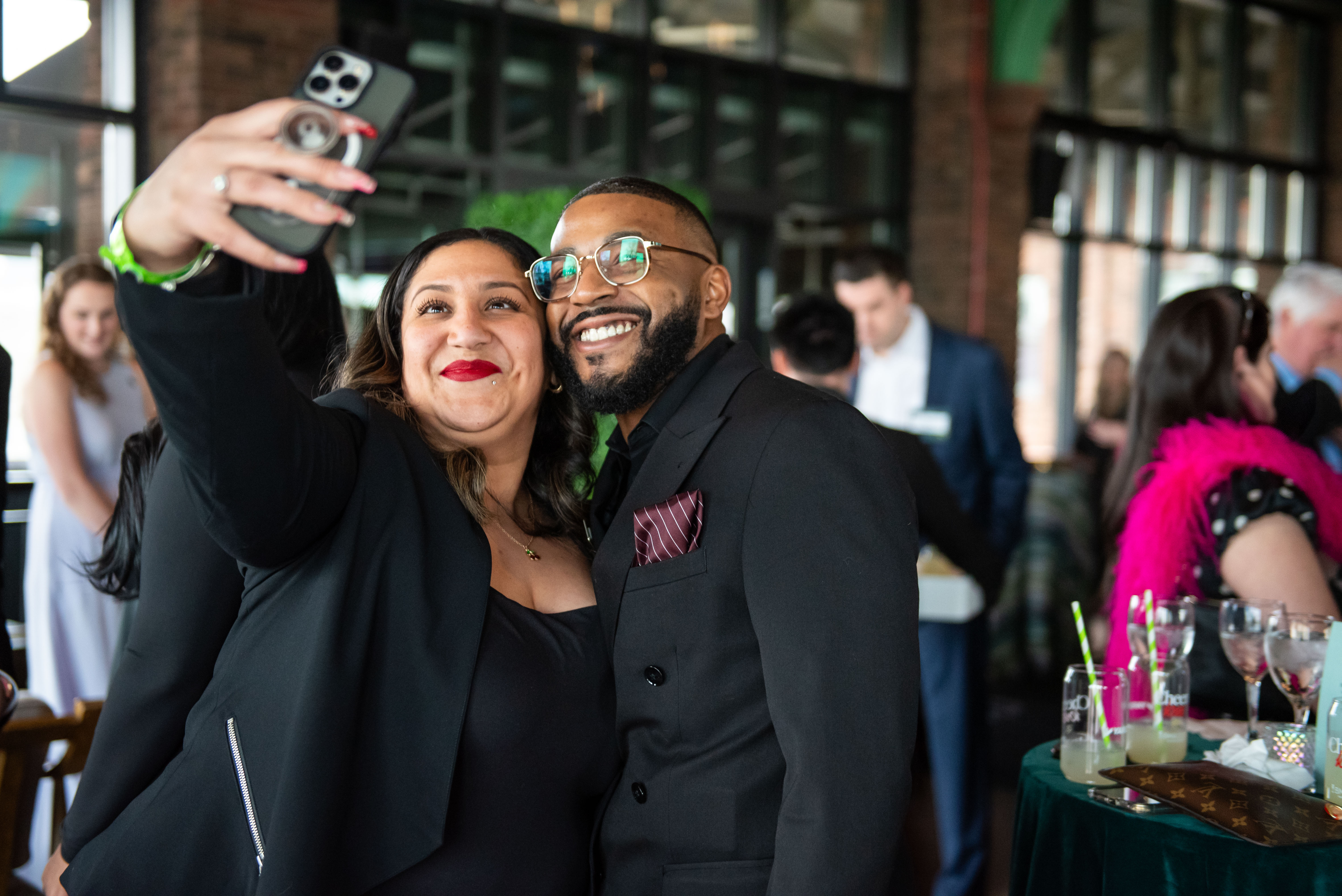 Two people taking a selfie at a lively indoor event.
