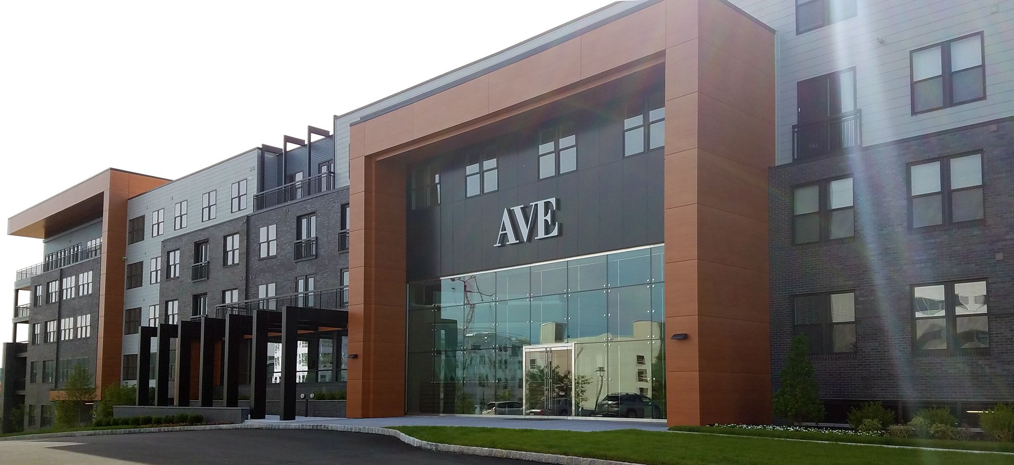 Modern multi-story building with large windows and a prominent entrance displaying "AVE."