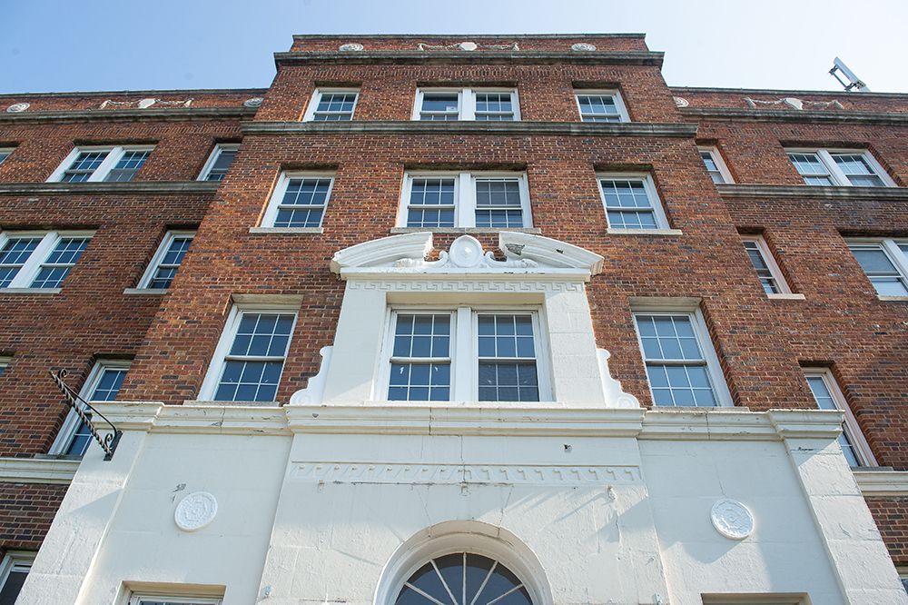 A historic brick building with a decorative entrance and multiple windows.
