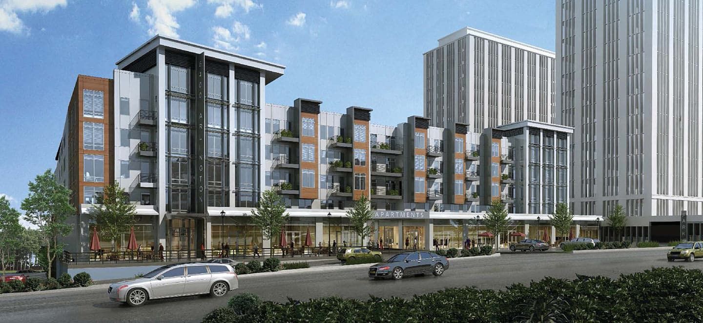 Modern urban building with retail spaces and surrounding greenery.