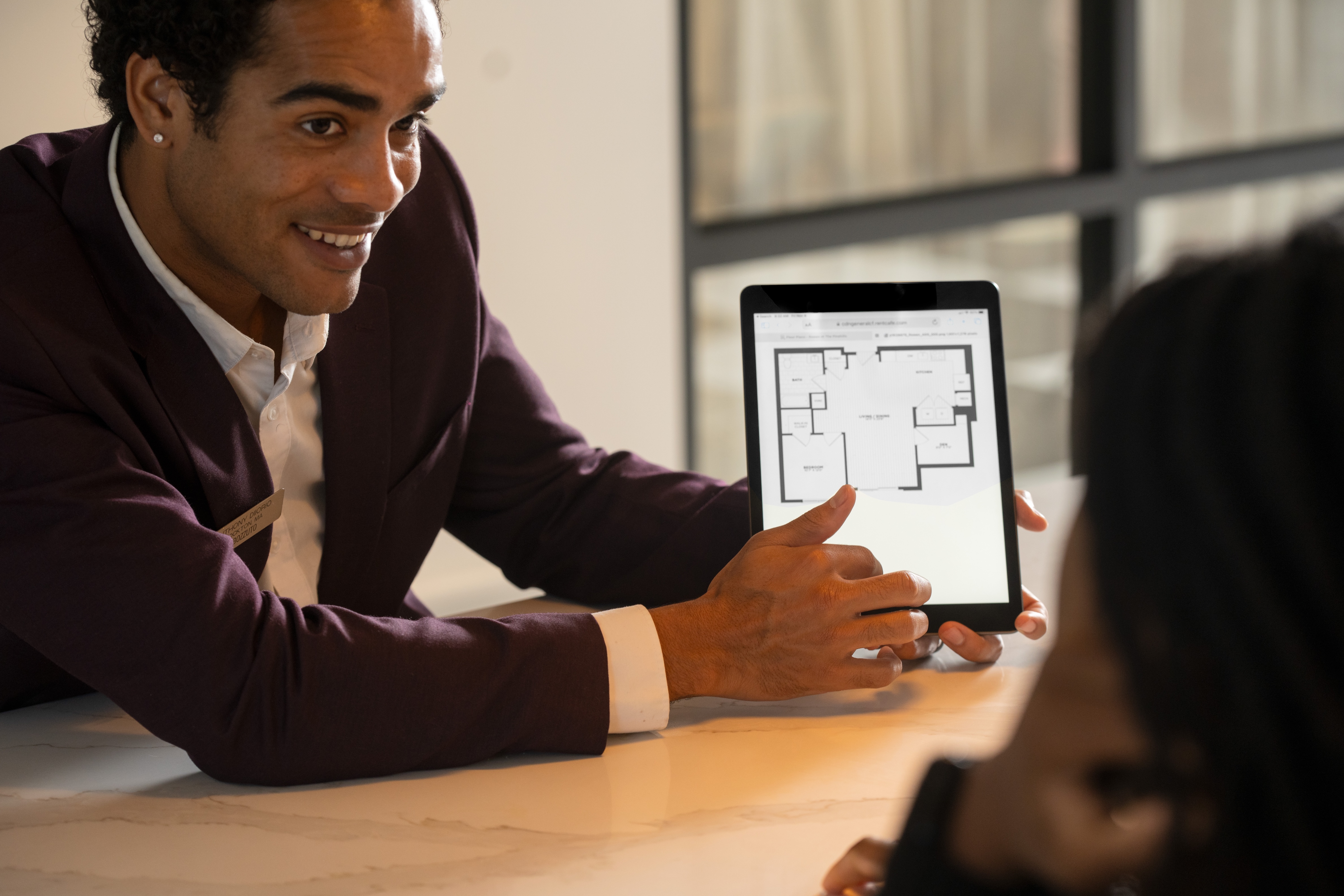 Man showing a floor plan on a tablet to a person