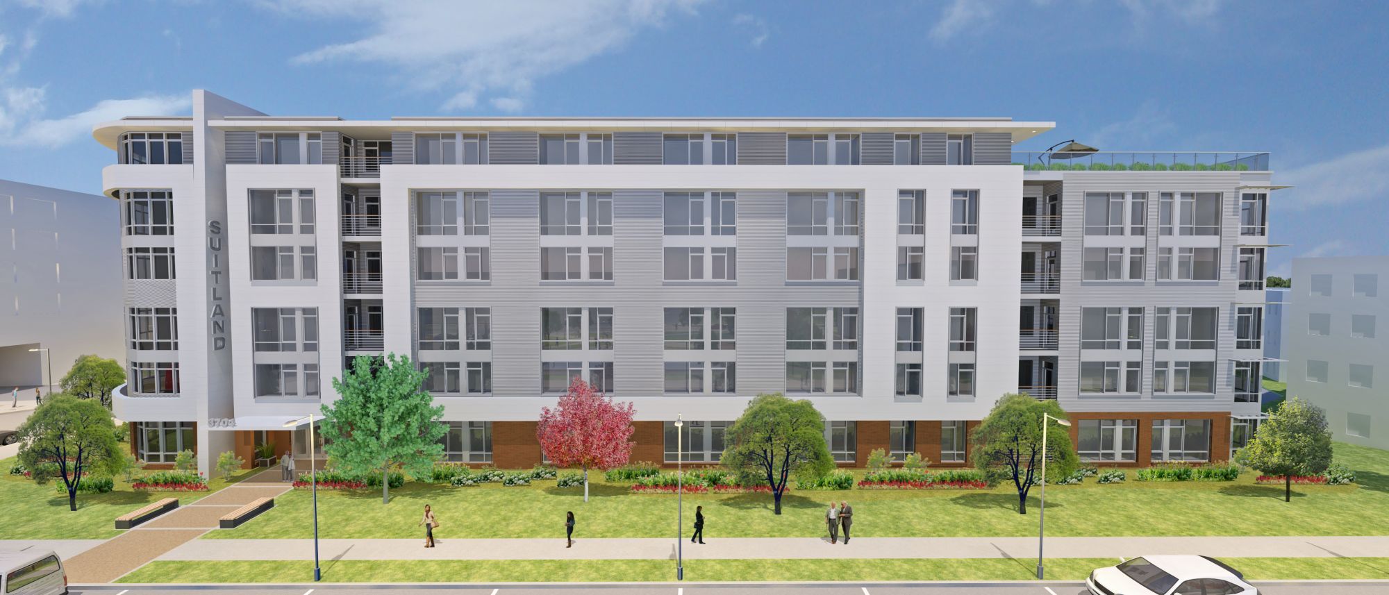 Four-story modern apartment building with trees and people in front.